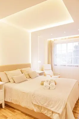 a white bedroom with a large bed with towels on it at Apartamento completo con wifi en Betanzos in Betanzos
