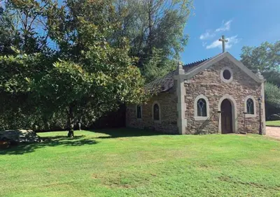 an old stone church on a grass field at Casa Do Rivera in Cospeito