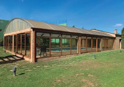 a large building with glass windows in a field at Casa Do Rivera in Cospeito