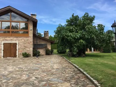 a house with a tree and a stone driveway at Casa Do Rivera in Cospeito