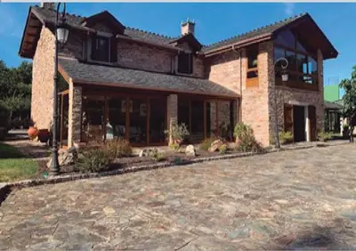 a large brick house with a large driveway at Casa Do Rivera in Cospeito