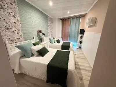 a bedroom with two beds with green pillows at Un rincón romano in Caldas de Reis