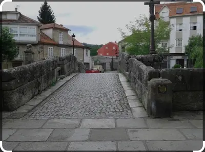 a stone walkway in a city with houses and buildings at Un rincón romano in Caldas de Reis