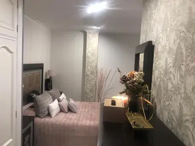 a bedroom with a bed with pink sheets and a mirror at Un rincón romano in Caldas de Reis