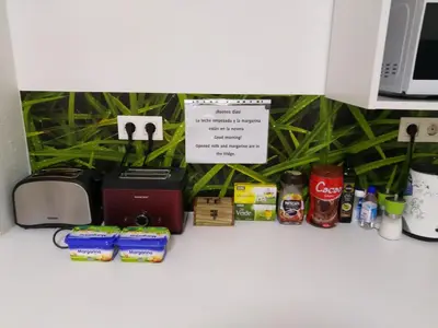 a counter with a toaster and other food and drinks at Grelo Hostel in Ourense