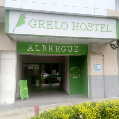 a store with a green and white sign on it at Grelo Hostel in Ourense