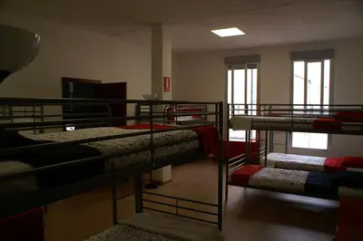 a room with three bunk beds in a room at Grelo Hostel in Ourense