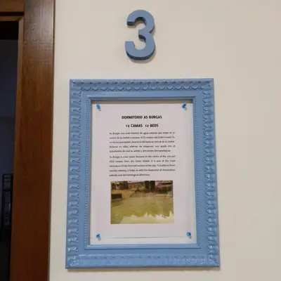 a framed picture of a number three on a wall at Grelo Hostel in Ourense