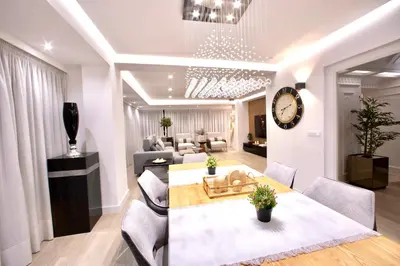 a living room with a table and chairs and a clock at Cathedral Boutique by Lugo Collection in Lugo