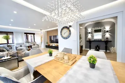 a dining room and living room with a large clock on the wall at Cathedral Boutique by Lugo Collection in Lugo