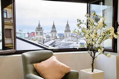 a chair in front of a window with a view of the city at Cathedral Boutique by Lugo Collection in Lugo