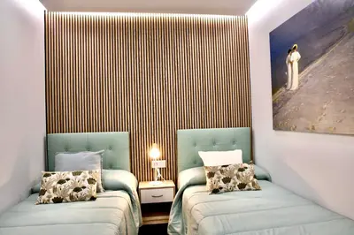 two beds in a room with a painting on the wall at Cathedral Boutique by Lugo Collection in Lugo