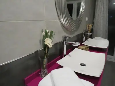 a bathroom with two sinks and a vase with flowers at Refugio O Castro in Barreiros