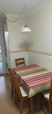 a dining room table with a striped table cloth on it at El apartamento de Ana y Mariano in Foz