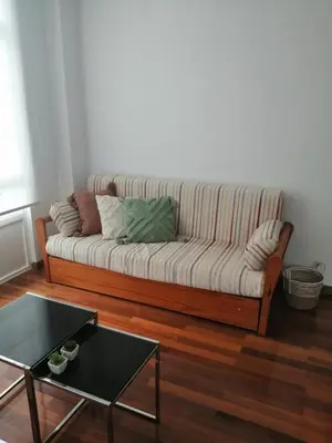 a couch in a living room with a table at Alojamiento Santa Maria Bertamirans II in Ortoño