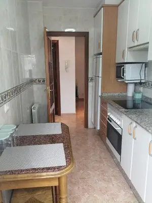 a small kitchen with a table and a stove at Alojamiento Santa Maria Bertamirans II in Ortoño