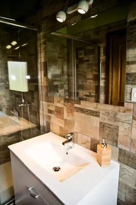 a bathroom with a sink and a large mirror at Apartamentos turísticos LAS CARBALLEDAS in Rabanal del Camino
