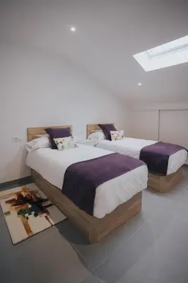 two beds sitting in a room at Casas del Pedregal apartamento 3 in A Estrada