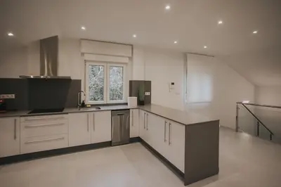 a large kitchen with white cabinets and a window at Casas del Pedregal apartamento 3 in A Estrada