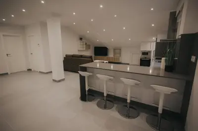 a kitchen and living room with a counter and stools at Casas del Pedregal apartamento 3 in A Estrada