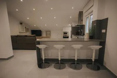 a kitchen with a counter and bar with stools at Casas del Pedregal apartamento 3 in A Estrada
