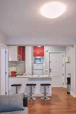 a kitchen with a counter and stools in a room at Apartamento de Julia in Santiago de Compostela