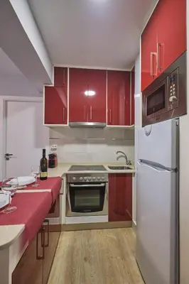 a kitchen with red cabinets and a refrigerator at Apartamento de Julia in Santiago de Compostela