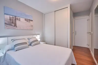 a white bedroom with a bed with two pillows at Apartamento de Julia in Santiago de Compostela