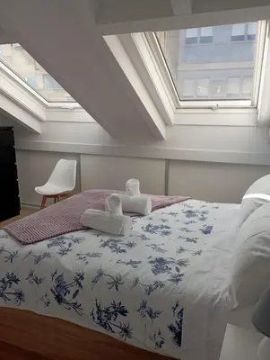 a bedroom with a bed with towels on it at Atico Salvadas in Santiago de Compostela