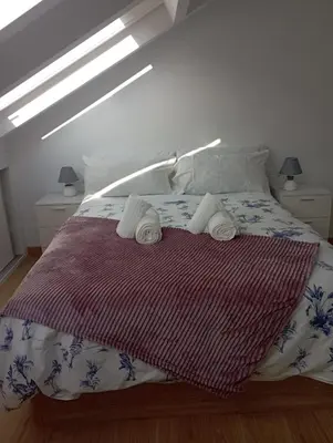 a bedroom with a bed with towels on it at Atico Salvadas in Santiago de Compostela