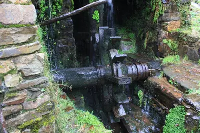 a black fire hydrant attached to a stone wall at Apartamentos Rurales Veredas in Santa Eulalia de Oscos
