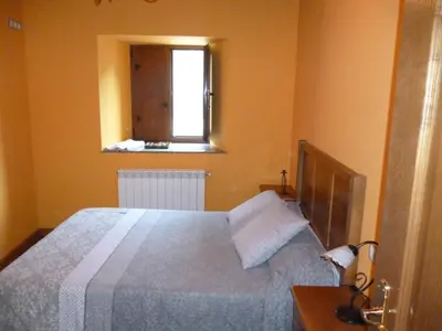 a bedroom with a large bed and a window at Apartamentos Rurales Veredas in Santa Eulalia de Oscos