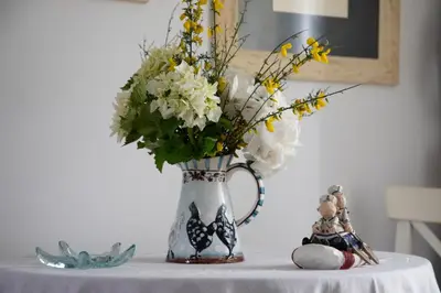 a vase with flowers in it on a table at Casa San Martiño - Teo in Rua De Francos