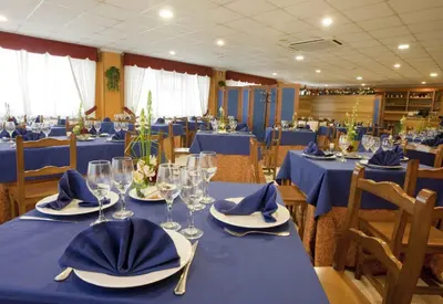 a dining room with blue tables with glasses and napkins at Casa San Martiño - Teo in Rua De Francos