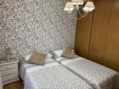 a bedroom with a bed and a wall with floral wallpaper at Casa San Martiño - Teo in Rua De Francos