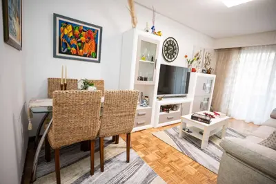 a living room with a table and a television at Piso Milà in Ourense