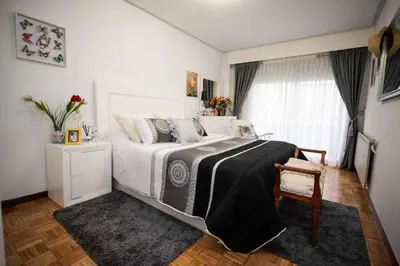 a bedroom with a bed with a black blanket on it at Piso Milà in Ourense