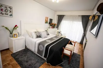 a bedroom with a white bed and a window at Piso Milà in Ourense