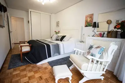 a bedroom with a bed and a couch and a chair at Piso Milà in Ourense
