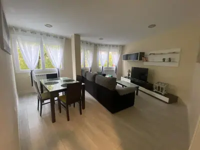 a living room with a couch and a table and chairs at La casa de las Flores in Ponferrada