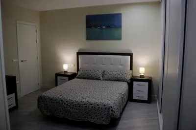 a bedroom with a bed and two lights on two night stands at La casa de las Flores in Ponferrada