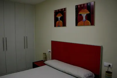 a bedroom with a bed and two pictures on the wall at La casa de las Flores in Ponferrada