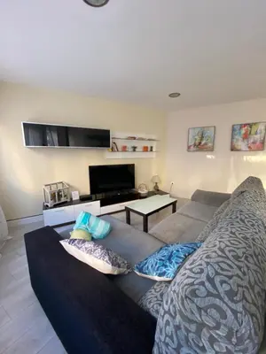 a living room with a couch and a tv at La casa de las Flores in Ponferrada
