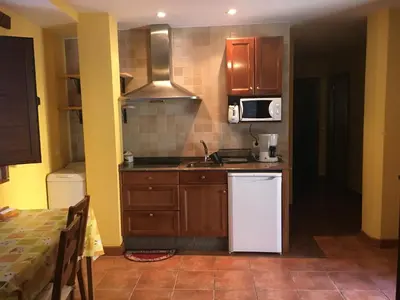 a kitchen with a white refrigerator and a sink at Tía María in Cerredo