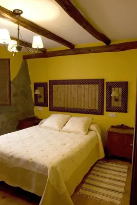 a bedroom with a large bed and yellow walls at Tía María in Cerredo
