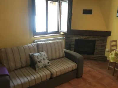 a living room with a couch and a fireplace at Tía María in Cerredo