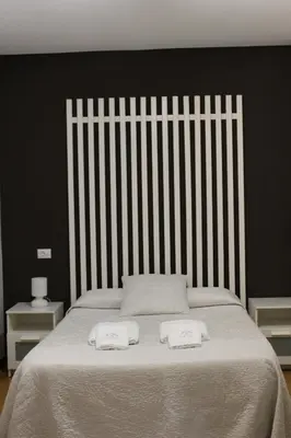 a white bed with two towels on top of it at Pensión NAVIA A Pontenova in A Pontenova