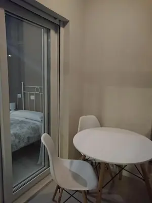a white table and chairs in a room with a bedroom at Pensión NAVIA A Pontenova in A Pontenova