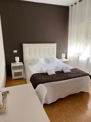 a bedroom with a large white bed with two tables at Pensión NAVIA A Pontenova in A Pontenova