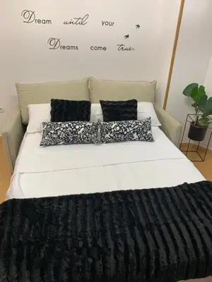 a bed with black and white pillows on it at MANSIÓN DEL INDIANO in Viveiro